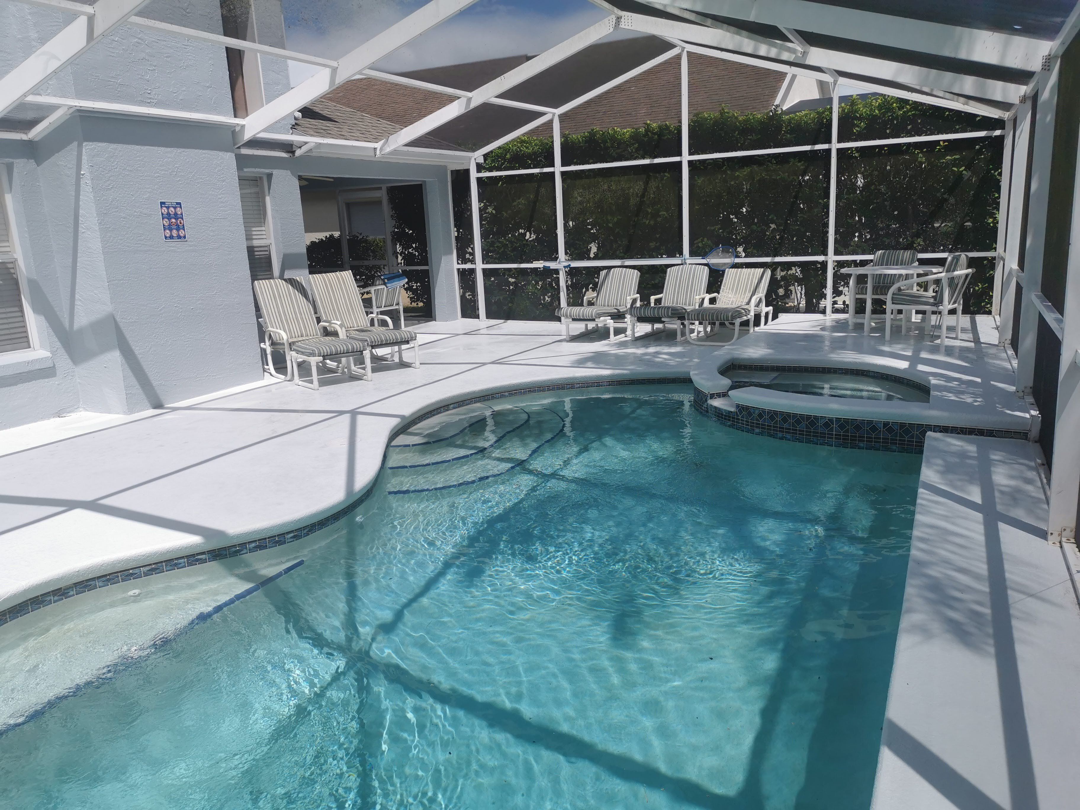 Une piscine avec des chaises longues et un jacuzzi.
