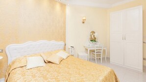 A hotel room with a large bed, a desk with a mirror, and a wardrobe. - Impero Vaticano San Pietro (Rome)