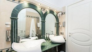A bathroom with two sinks, a large mirror, and a towel rack. - Impero Vaticano San Pietro (Rome)