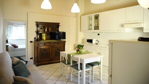 A compact living space with a dining area, kitchenette, and a sofa. - SweetHome S.Frediano 3bdr (Firenze)