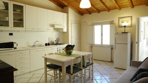 A kitchen with white cabinets, a dining table with chairs, a refrigerator, and a window. - SweetHome S.Frediano 3bdr (Firenze)