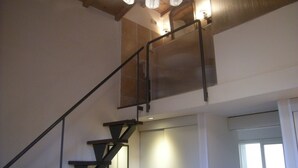 A staircase with a metal railing leading to a second floor. There is a window on the second floor allowing natural light to enter. - SweetHome S.Frediano 3bdr (Firenze)