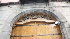 A large wooden double door with metal hinges and decorative carvings, set within an arched stone frame. - Luxurious apartment in an ancient noble palace in the historic center of Naples (Napoli)