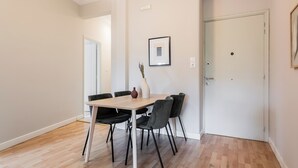 A dining area with a wooden table and black chairs, a vase with dried plants, and a framed picture on the wall. - UPSTREET Zeus Temple View 2BD Apt Acropolis-Plaka (Athens)