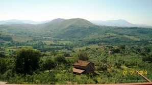 A rural landscape with rolling hills, scattered trees, and a small building in the foreground. - sweet home sabina    (Montopoli di Sabina)