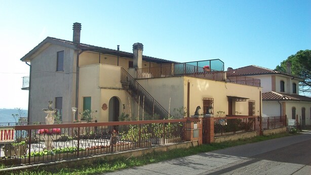 A two-story building with a balcony, a staircase, and a fenced garden area. - sweet home sabina    (Montopoli di Sabina)