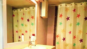 A bathroom with a sink, mirror, and toilet. The shower curtain has colorful star patterns. - Duplex dream on the slopes in the Sierra Nevada, Pradollano (Sierra Nevada)