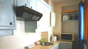 A compact kitchen with white cabinets, a microwave, and a toaster. - Duplex dream on the slopes in the Sierra Nevada, Pradollano (Sierra Nevada)