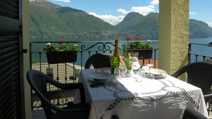 A table set for dining with a view of mountains and a lake. - Casa Gabriella apartment with lake view (San Siro)