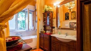 A bathroom with wooden cabinets, a sink, and a window with curtains. - ROMANTIC PERFECT FOR CATHEDRAL & EXHIBITION (Milano)