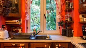 A kitchen with wooden cabinets, a sink, and a window with curtains. - ROMANTIC PERFECT FOR CATHEDRAL & EXHIBITION (Milano)