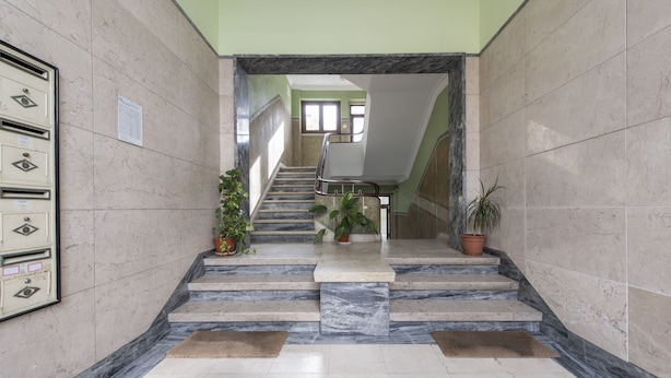 A marble-floored staircase with potted plants, leading to a landing with a view of the interior. - The ideal place near the Castle * 2BD APT CENTRAL * (Lisboa)