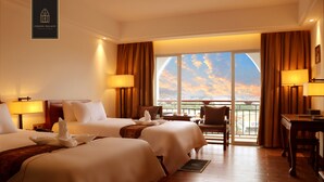 A hotel room with two beds, a desk, a chair, and a balcony with a view. - Chang Palace Vientiane (Vientiane)