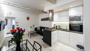 Una cocina moderna con armarios blancos, horno integrado y una isla central.