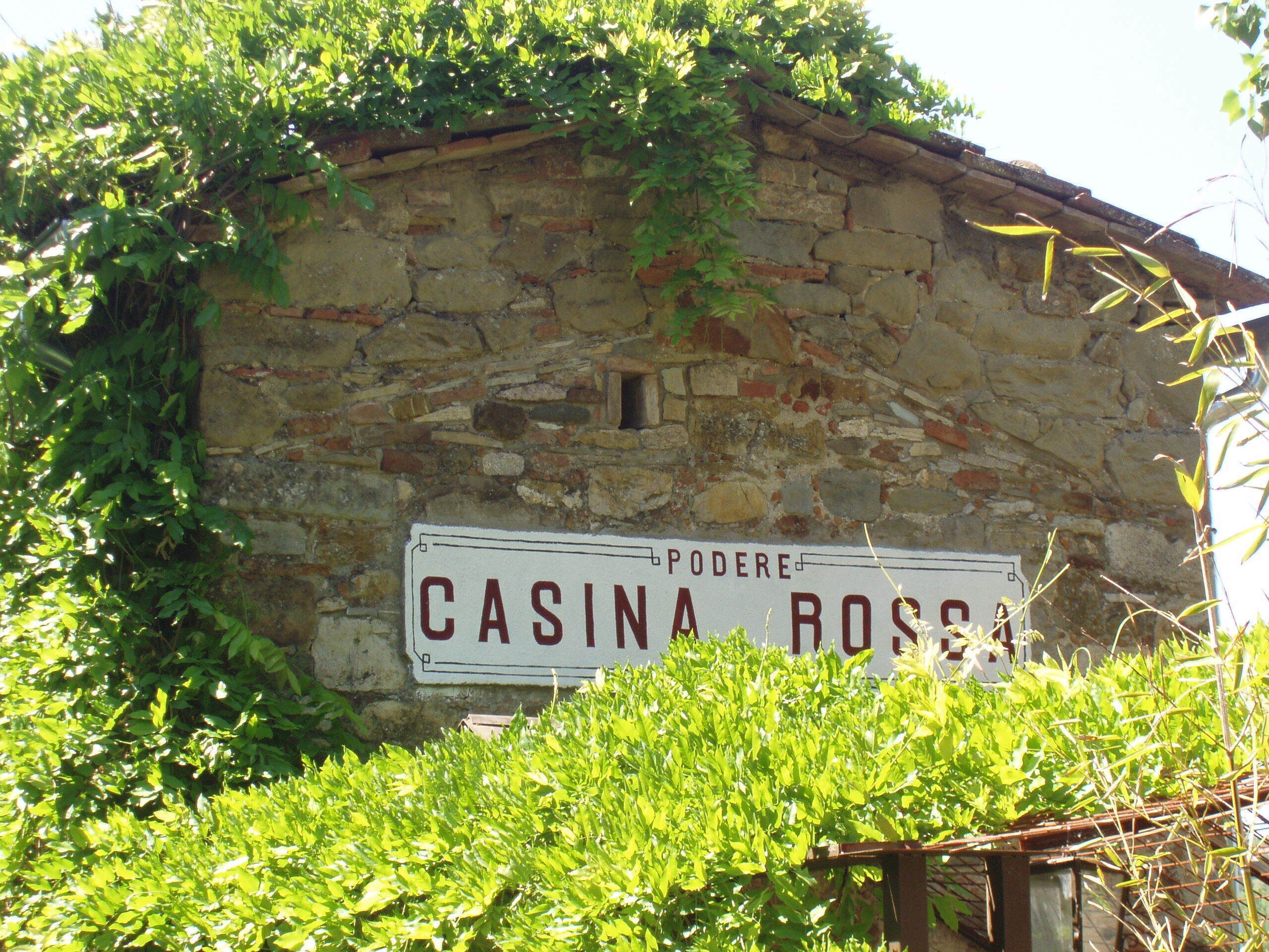 Un edificio de piedra con un letrero que dice "CASINA ROSSA".