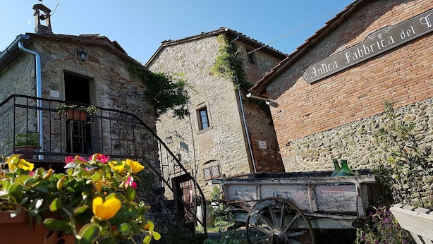 A rustic stone building with a sign reading "Antica fabbrica del T."