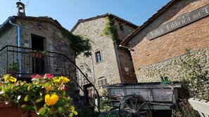 A rustic stone building with a sign reading "Antica fabbrica del T." - Typical farmhouse in Tuscany (poppi)