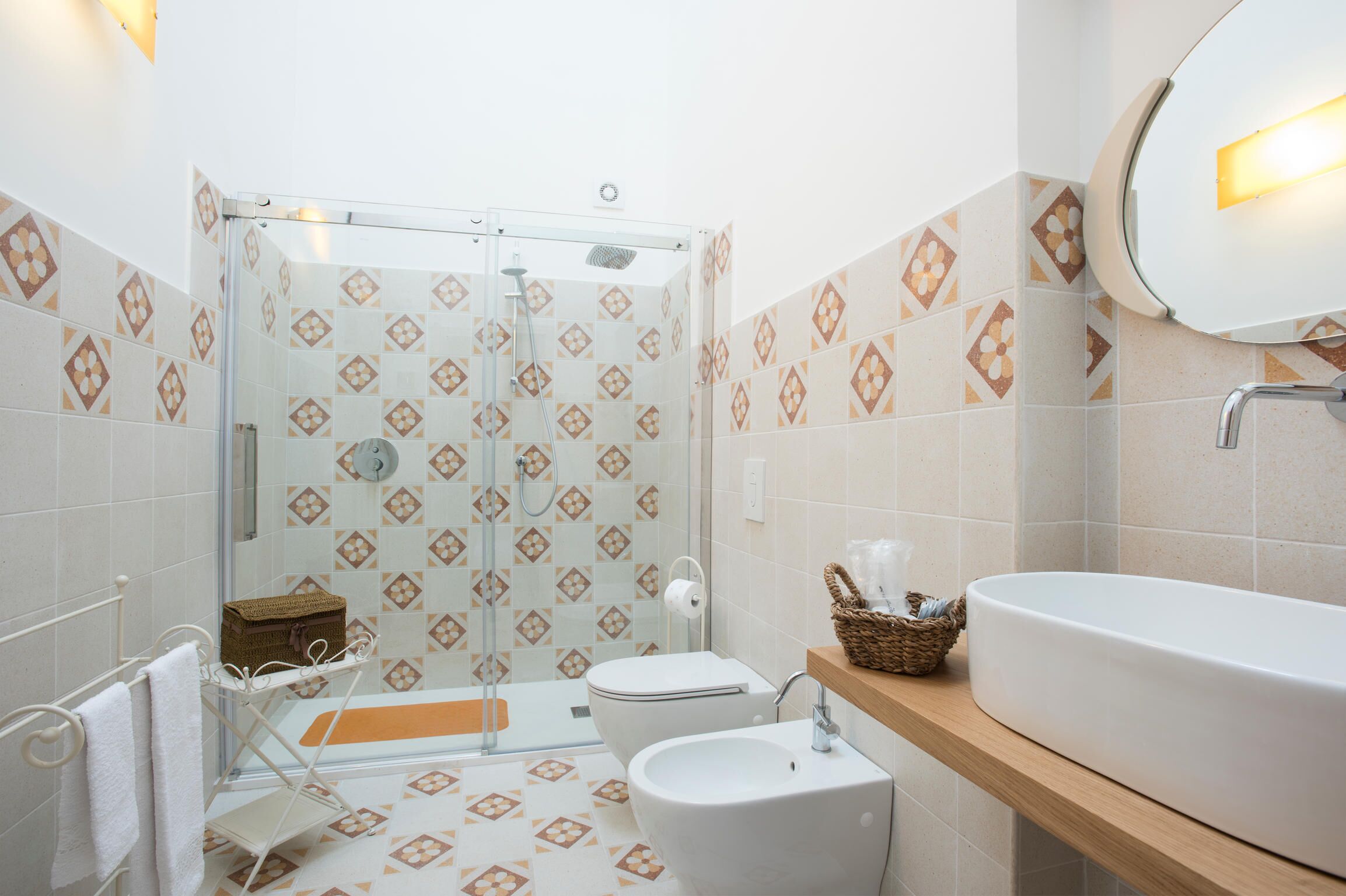 Ein Badezimmer mit Dusche, Toilette, Waschbecken und Spiegel.