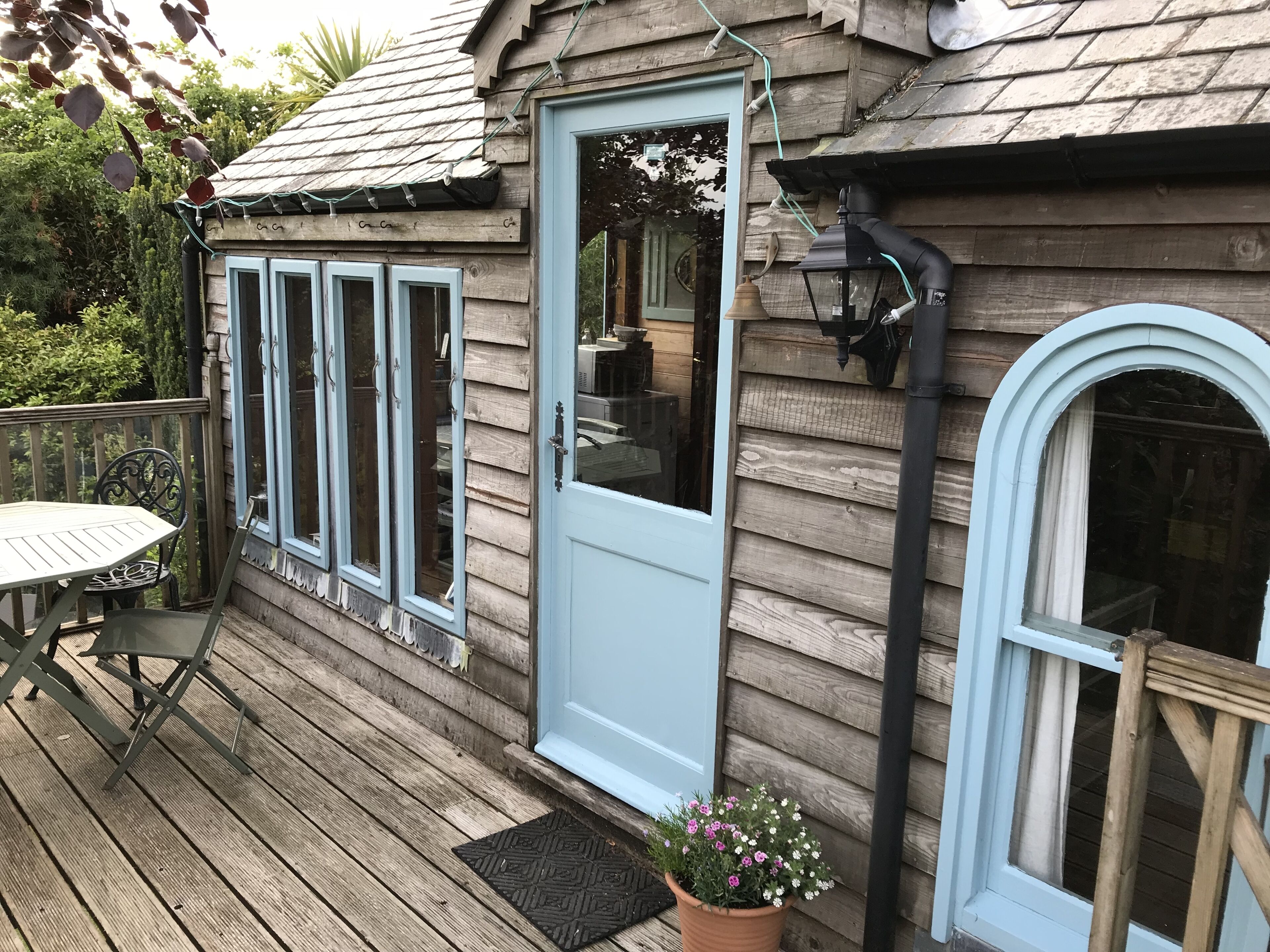 The Boathouse entrance and balcony with outdoor seating for 4