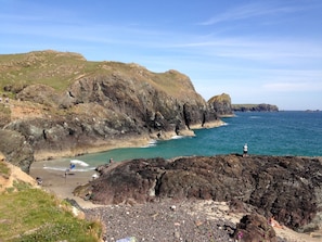 A rocky coastline with a beach, cliffs, and the sea.