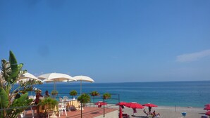 A beachside restaurant with outdoor seating, umbrellas, and a view of the sea. - Gardenhouse on the largest beaches of Taormina apartment n. 1 for 4 people (Mazzeo, Taormina)