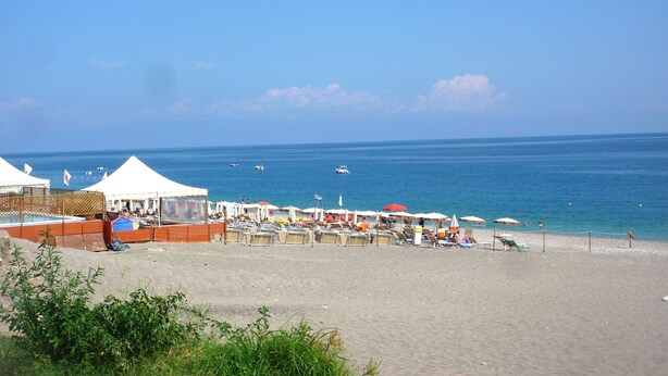 A beach with tents and umbrellas, a sandy shore, and the sea in the background. - Gardenhouse on the largest beaches of Taormina apartment n. 1 for 4 people (Mazzeo, Taormina)