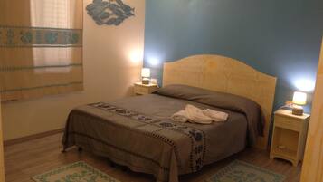 Cozy retreat with a neatly made bed, bedside tables, and a decorative wall piece.