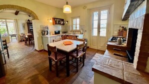 A spacious kitchen with a large island, a built-in oven, and a dining area with wooden chairs. - Charming Maremma Villa w/Swimming Pool, Countryside Serenity and Beaches Nearby (Magliano in Toscana)