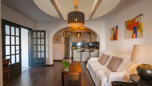 A modern living room with a sofa, a coffee table, and a dining area with a kitchen in the background. - Two Bedroomed Villa With Private Pool. (Torrevieja)