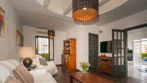 A modern living room with a sofa, a wooden coffee table, a lamp, a cabinet, and a TV. - Two Bedroomed Villa With Private Pool. (Torrevieja)