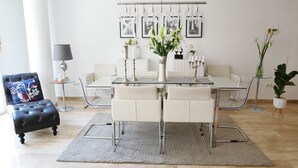 A modern dining area with a glass table, white chairs, and a chandelier. - beautiful, quiet, great apt downtown, near the beach. Ask for parking (Alicante)