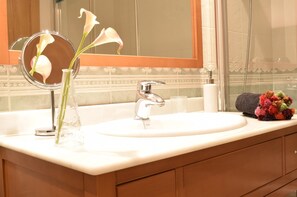 A bathroom with a sink, mirror, and a vase with flowers. - beautiful, quiet, great apt downtown, near the beach. Ask for parking (Alicante)