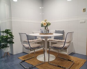A dining area with a round table, two chairs, a vase with flowers, and a potted plant. - beautiful, quiet, great apt downtown, near the beach. Ask for parking (Alicante)