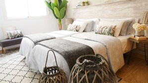A bedroom with two beds, a large plant, and a bedside table with books and a vase. - beautiful, quiet, great apt downtown, near the beach. Ask for parking (Alicante)