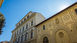 Ein Gebäude mit klassischer Architektur, das gewölbte Fenster und dekorative Stuckarbeiten aufweist.