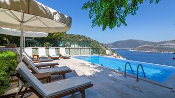 Una piscina al aire libre, sillones reclinables de piscina