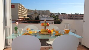 A balcony with a glass table set for breakfast, including fruits, croissants, and orange juice. - At 300 m from the beach, a 2 bedroom penthouse with an amazing terrace.  Center, cable tv (Albufeira)