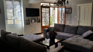 Un salon avec un canapé, une table basse et un téléviseur fixé au mur.