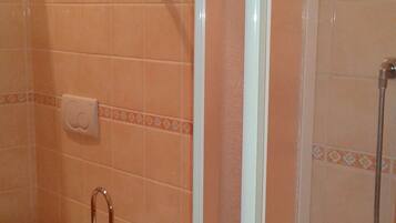 A bathroom with a toilet, bidet, and shower.