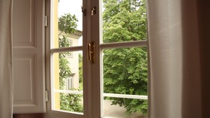 Una ventana con vista a un árbol y un edificio.