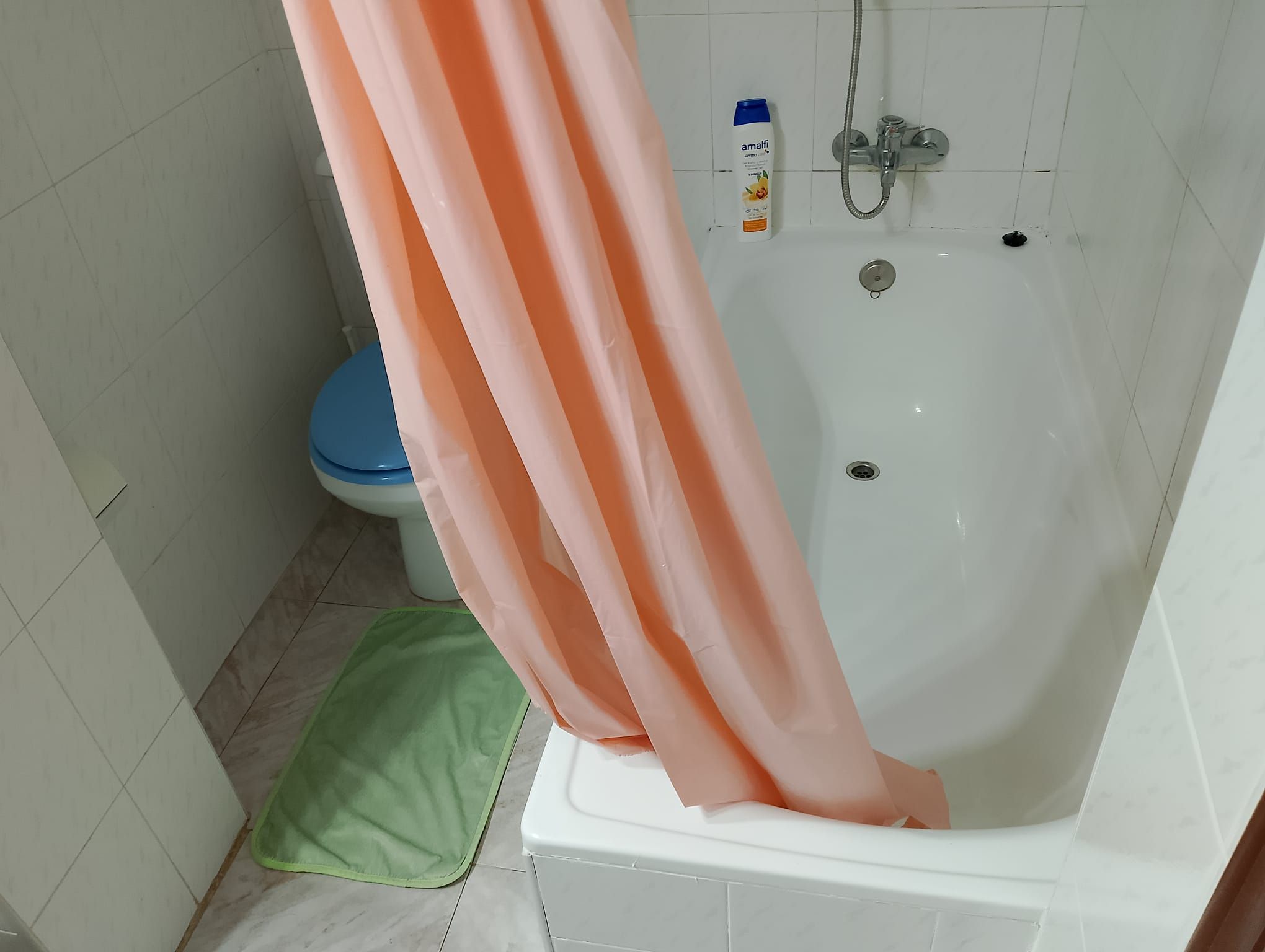 Une salle de bain avec une baignoire, des toilettes et un rideau de douche.