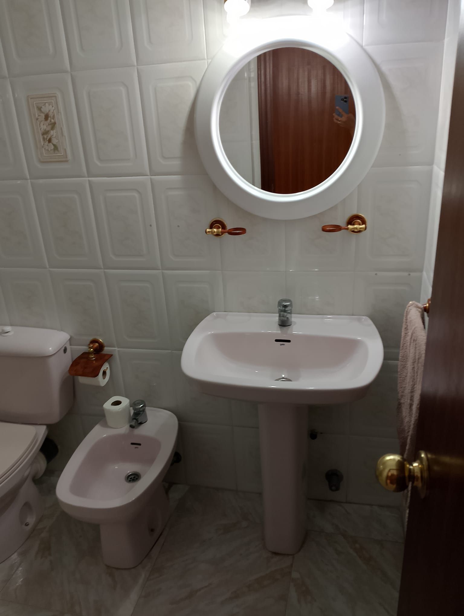 Un baño con inodoro, lavabo y espejo.