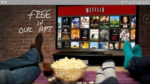 A person watching Netflix on a TV with a selection of movies displayed.