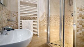 A bathroom with a sink, a glass shower enclosure, and a towel rack. - HOME SWEET HOME (Napoli)