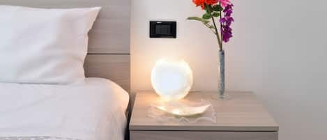 Una cama bien hecha con una almohada blanca y una colcha blanca.