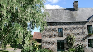 A stone building with a sloped roof, a chimney, and a small window. - Luxury Family Farmhouse, Pool and Games Room. Perfect for DDay, Mont st Michel (Le Mesnil-Garnier)
