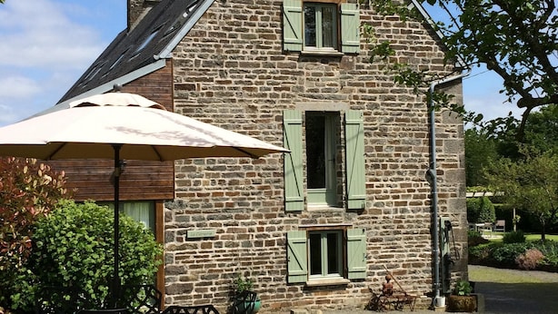A stone building with a wooden deck and outdoor seating. - Luxury Family Farmhouse, Pool and Games Room. Perfect for DDay, Mont st Michel (Le Mesnil-Garnier)