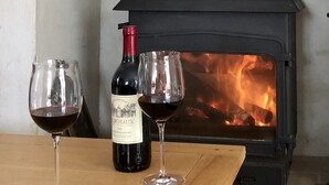 A fireplace with a bottle of wine and two glasses on a wooden table. - Luxury Family Farmhouse, Pool and Games Room. Perfect for DDay, Mont st Michel (Le Mesnil-Garnier)