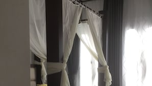 A bedroom with a four-poster bed, a canopy, and a view of the outdoors through a window with curtains. - Extremely private villa with own pool (heating optional) - sleeps up to 6 (El Gouna)