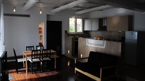 A modern kitchen with a dining area, wooden flooring, and a built-in oven. - Melolia A2 holiday home with pool and fabulous views (Alyki)